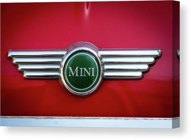 Mini Canvas Print featuring the photograph Mini Cooper car logo on red surface by Michalakis Ppalis
