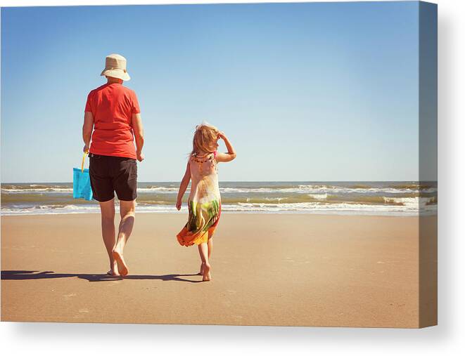 Granddaughter Canvas Print featuring the photograph Rear View Of Granddaughter And Grandmother Walking On Sand At Beach by Cavan Images