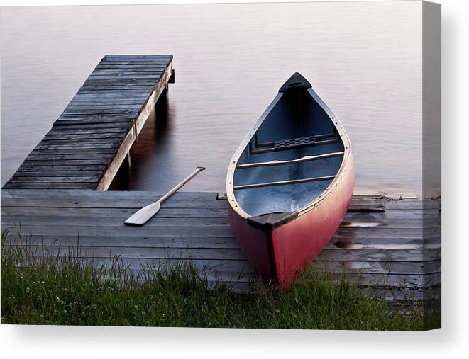 Water's Edge Canvas Print featuring the photograph Red Canoe On A Dock by Imaginegolf