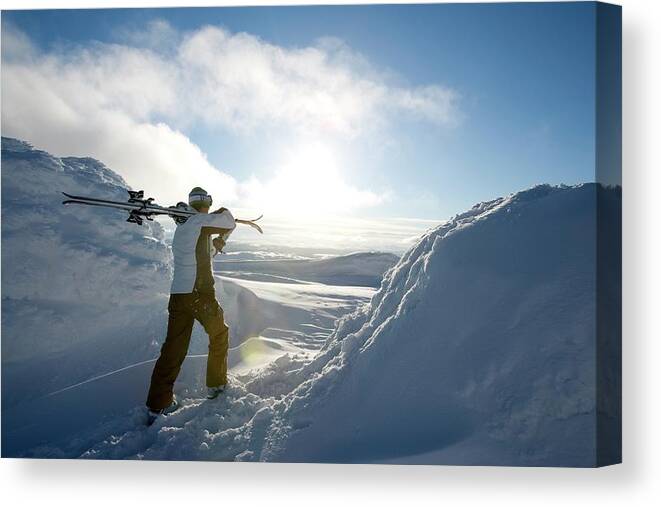 Skiing Canvas Print featuring the photograph Skier Carrying Skies On The Shoulder by Henrik Trygg