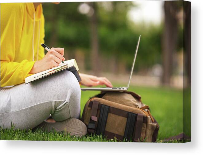 Student Canvas Print featuring the photograph Spanish Student Working Sitting On The Grass With Laptop And Agenda by Cavan Images