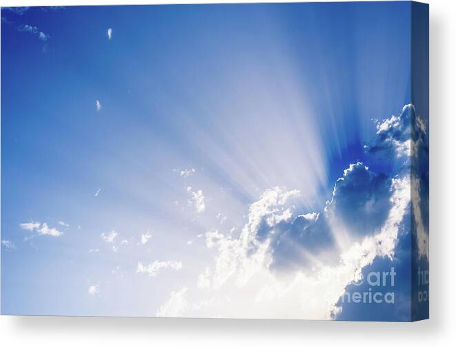 Background Canvas Print featuring the photograph Sunbeams rising from a large cloud in intense blue sky on a summer afternoon by Joaquin Corbalan