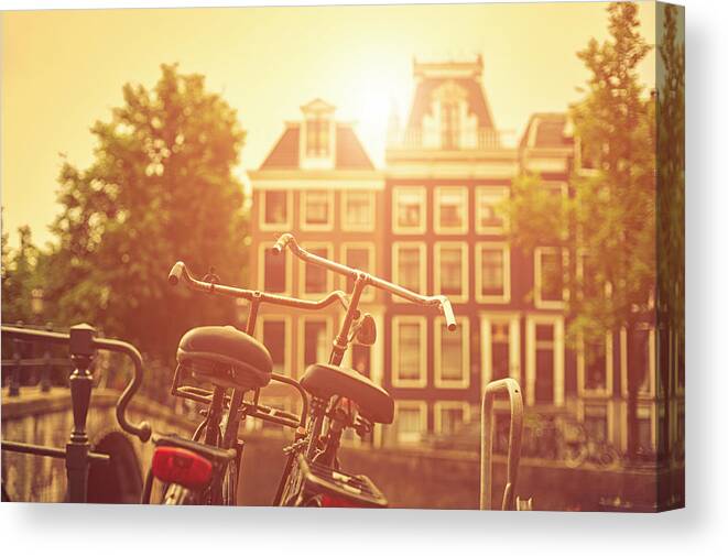 Orange Color Canvas Print featuring the photograph Two Old Bicycles In Amsterdam At Sunset by Cirano83