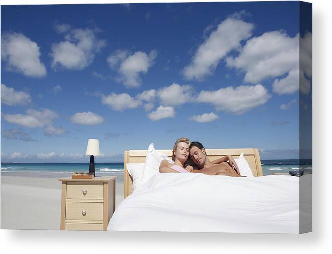 Mid Adult Men Canvas Print featuring the photograph Couple Sleeping in a Bed on the Beach #1 by Digital Vision.