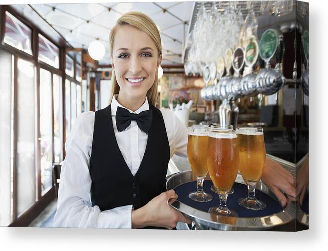 Working Canvas Print featuring the photograph Denmark, Aarhus, Portrait of young woman holding tray with beer glasses #1 by Yuri Arcurs