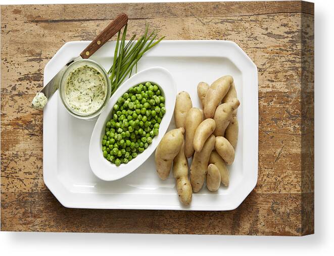 Wood Canvas Print featuring the photograph Fingerling potatoes and spring peas served with a chive compound butter by Ryan Benyi Photography