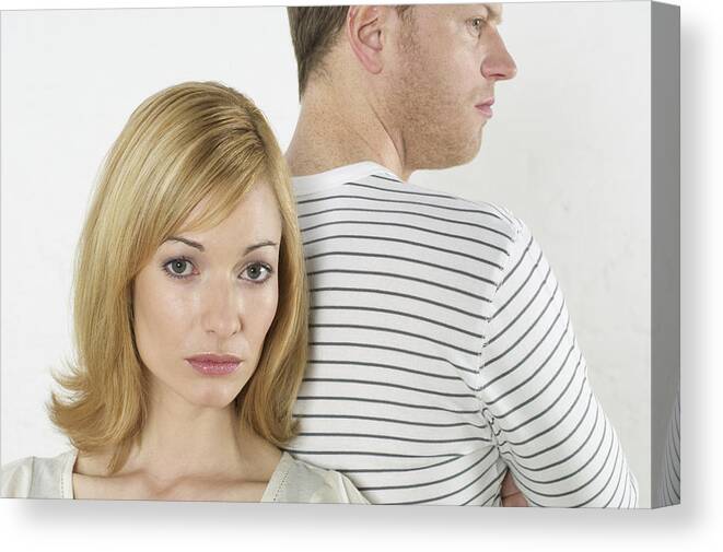 Young Men Canvas Print featuring the photograph Frustrated couple standing back to back #1 by Stock4b-rf