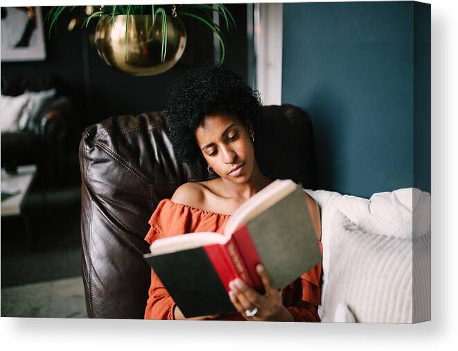 Apartment Canvas Print featuring the photograph Portrait of a young woman relaxing and reading in her Downtown Los Angeles apartment #1 by Lechatnoir