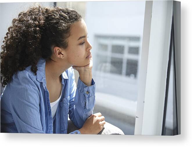 African Ethnicity Canvas Print featuring the photograph Sad and unhappy teenager looking out of the window #1 by Anna Frank