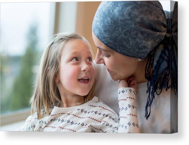 Tranquility Canvas Print featuring the photograph Young mom with cancer holds her daughter #1 by FatCamera