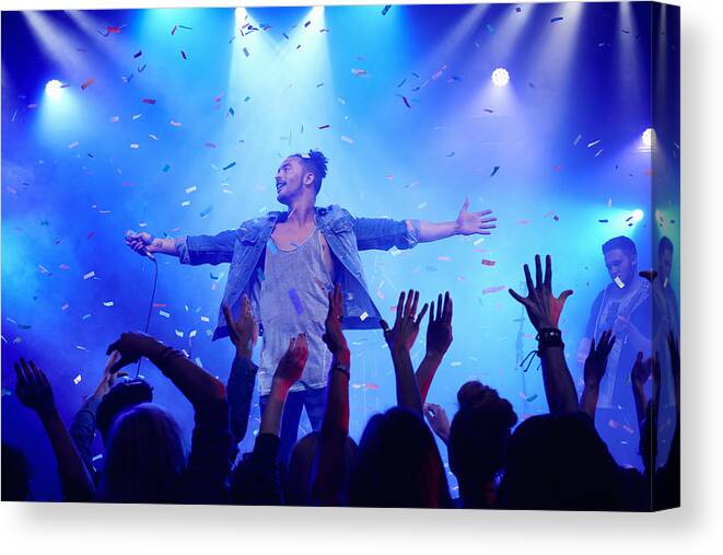 Young Men Canvas Print featuring the photograph Band performing on stage at music concert #2 by Flashpop