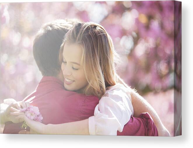 Young Couple Canvas Print featuring the photograph Couple hugging outdoors #2 by Justin Pumfrey