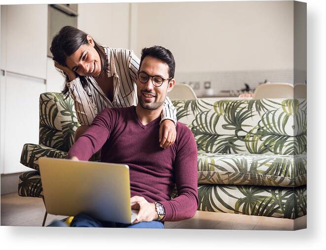 Laptop Canvas Print featuring the photograph Young couple having fun at home #2 by LeoPatrizi