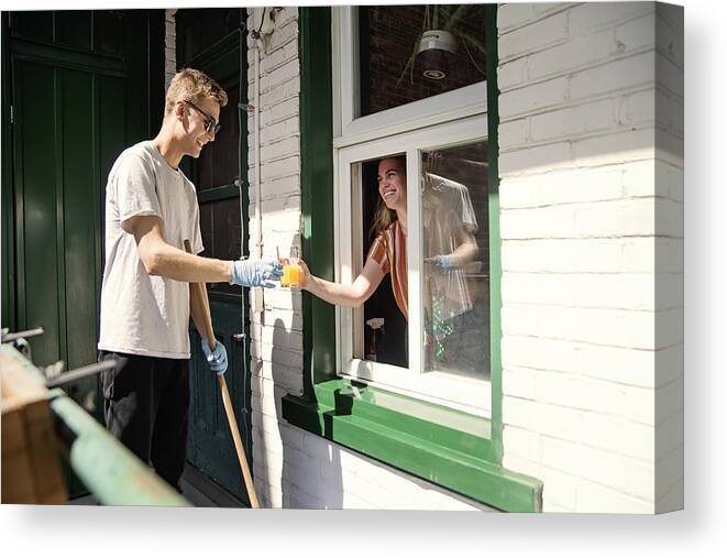 Young Men Canvas Print featuring the photograph Millenial couple cleaning city balcony in spring. #4 by Martinedoucet