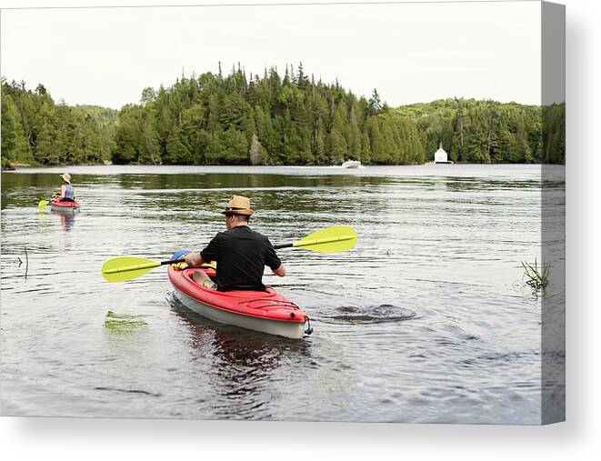 Tranquility Canvas Print featuring the photograph 50 + Man And Woman Kayaking On A Lake. by Martinedoucet
