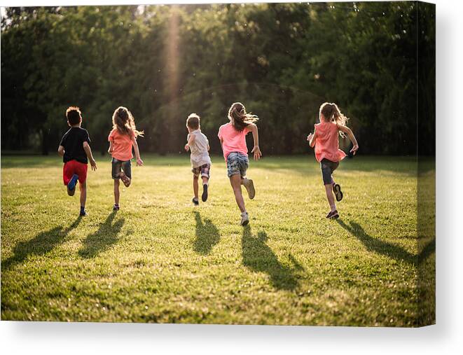 Shadow Canvas Print featuring the photograph Back view group of children running in nature by StockPlanets