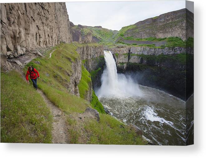 Palouse Falls State Park Canvas Print featuring the photograph Backpacker hiking along cliff at Palouse Falls State Park, Washington State, USA by Christopher Kimmel / Aurora Photos