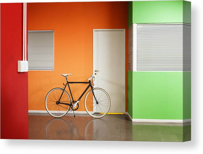 Orange Color Canvas Print featuring the photograph Black bicycle at the office. by Carlosalvarez