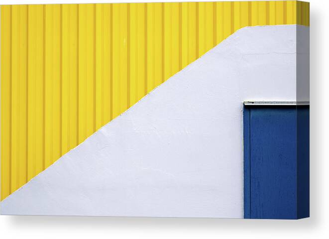 Minimalism Canvas Print featuring the photograph Blue close metal door on a white and yellow wall. by Michalakis Ppalis