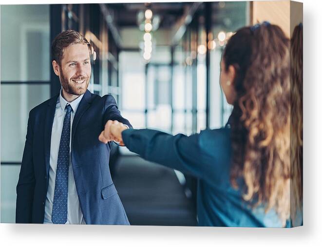 Office Canvas Print featuring the photograph Business persons greeting with a fist bump by Pixelfit