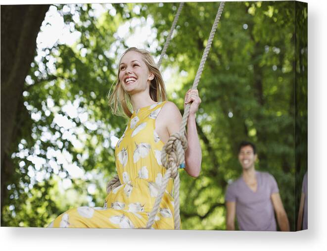 Rope Swing Canvas Print featuring the photograph Carefree woman on swing under trees by Paul Bradbury