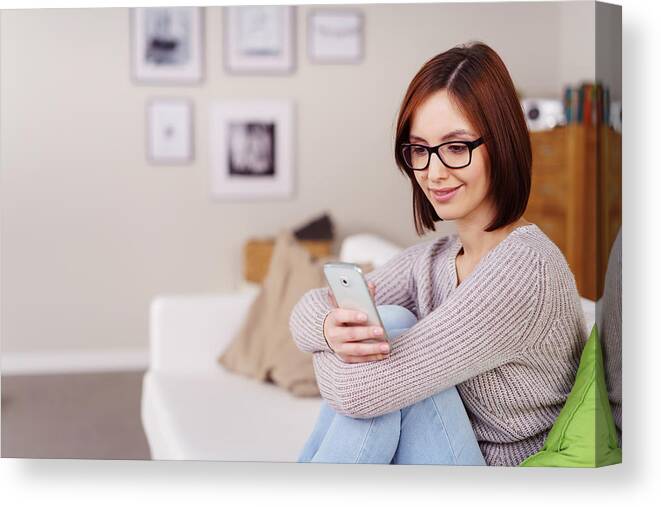Tranquility Canvas Print featuring the photograph Casual young woman reading a text message by Stockfour