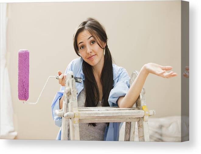 Working Canvas Print featuring the photograph Caucasian woman holding paint roller by Mike Kemp