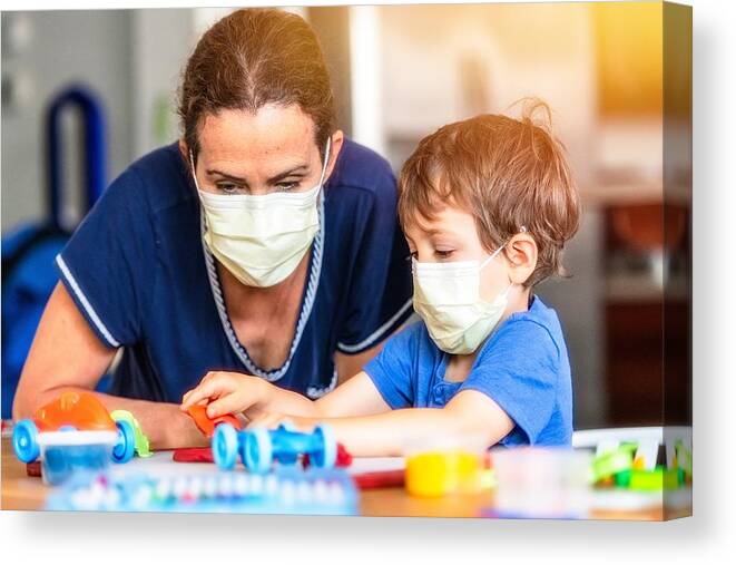 Toddler Canvas Print featuring the photograph Child boy learning with colorful clays while locked down because pandemic by Juanmonino