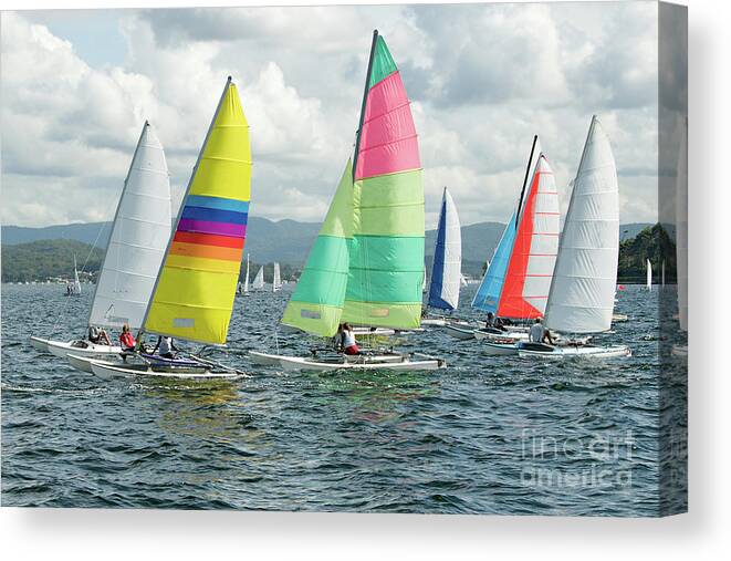 Female Canvas Print featuring the photograph Children Sailing small sailboats with colourful sails on an inla by Geoff Childs