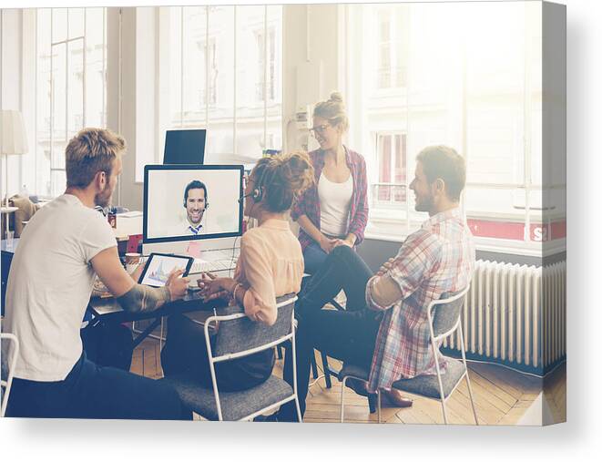 New Business Canvas Print featuring the photograph Coworkers doing a video conference in the conference room by Johnkellerman