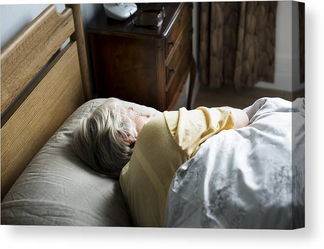 People Canvas Print featuring the photograph Elderly caucasian woman sleeping on the bed by Rawpixel