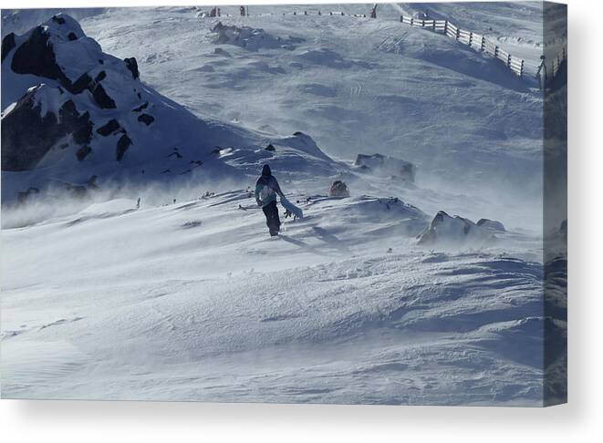 Skier Canvas Print featuring the photograph Extreme winter sport. Young pro snowboarder walks uphill in the halfpipe snow park. Teenager in blue white and black jacket is struggling with the wind. Low Tatras in Slovakia by Vaclav Sonnek