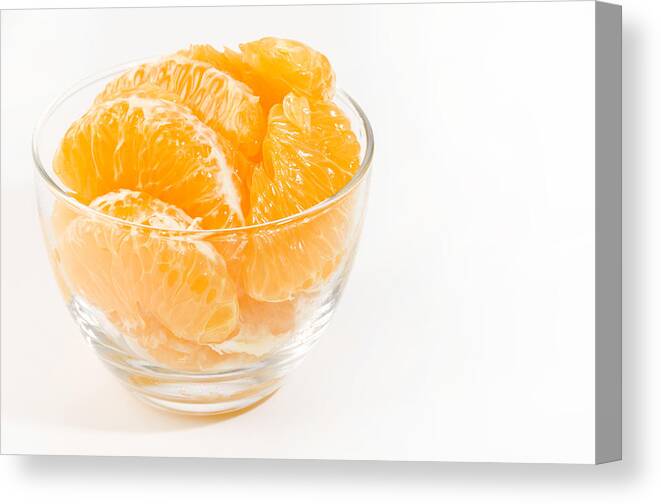 Orange Color Canvas Print featuring the photograph Fresh peeled Hassaku Orange in Transparent Glass bowl on white background by Karimitsu