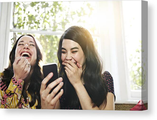 People Canvas Print featuring the photograph Friends laughing at a mobile phone by Ezra Bailey