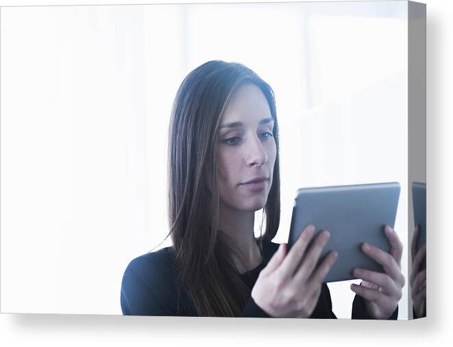 Working Canvas Print featuring the photograph Head and shoulders of young woman using digital tablet by Sigrid Gombert