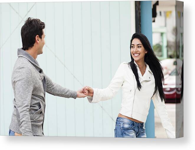 Young Men Canvas Print featuring the photograph Hispanic couple holding hands outdoors by Kevin Dodge