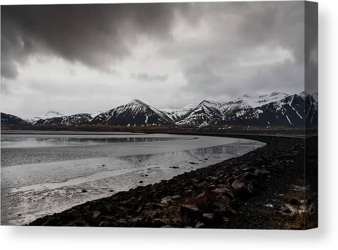 Iceland Canvas Print featuring the photograph Icelandic landscape with frozen lake and mountains covered in snow by Michalakis Ppalis