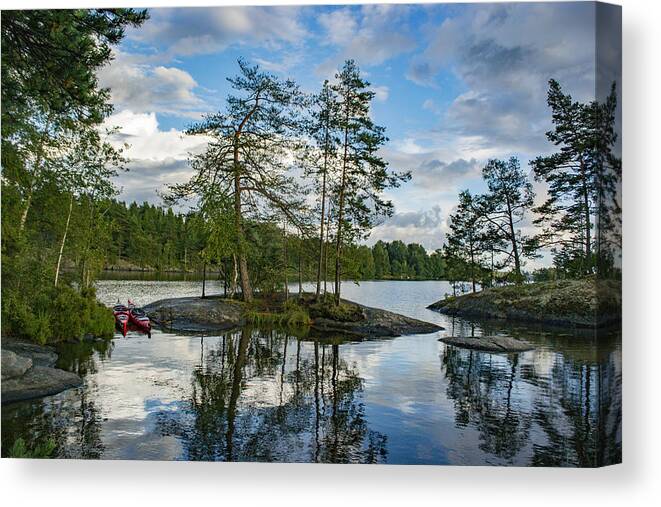 Water's Edge Canvas Print featuring the photograph Lake with trees and rocks in the Dalsland Lake District in Sweden. by Sjo