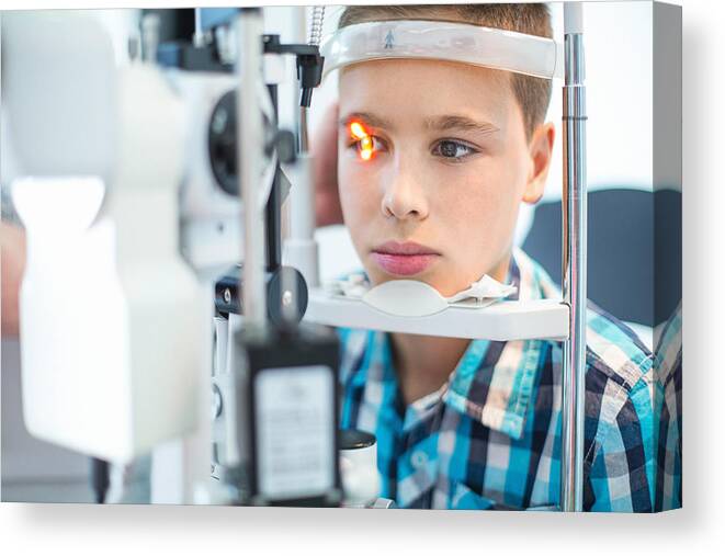 Slit Lamp Canvas Print featuring the photograph Little boy at optician's office. by Gilaxia