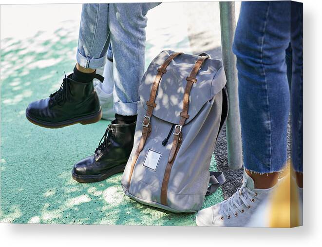 Young Men Canvas Print featuring the photograph Low section of students by backpack at campus by Klaus Vedfelt