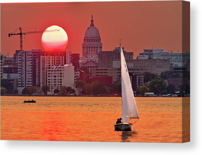 Madison Canvas Print featuring the photograph Madison Equinox - Sun setting near madison WI capitol dome with lake monona and sailboat by Peter Herman