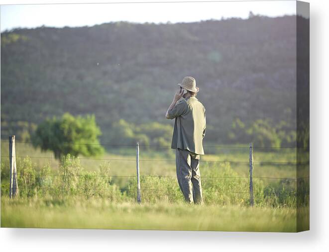 Scenics Canvas Print featuring the photograph Man talking with smartphone in landscape by Domino