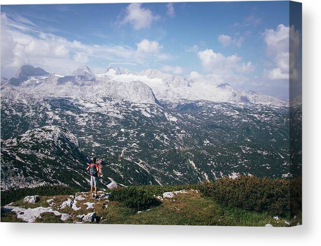 Sportive Canvas Print featuring the photograph Man with a backpack looks at the Dachstein massif by Vaclav Sonnek