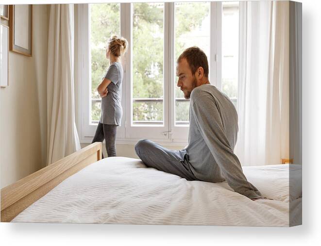 Mid Adult Men Canvas Print featuring the photograph Mid adult couple in bedroom, having disagreement by Kris Ubach and Quim Roser
