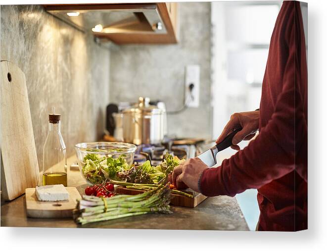Sweater Canvas Print featuring the photograph Midsection of man cutting vegetables by Morsa Images