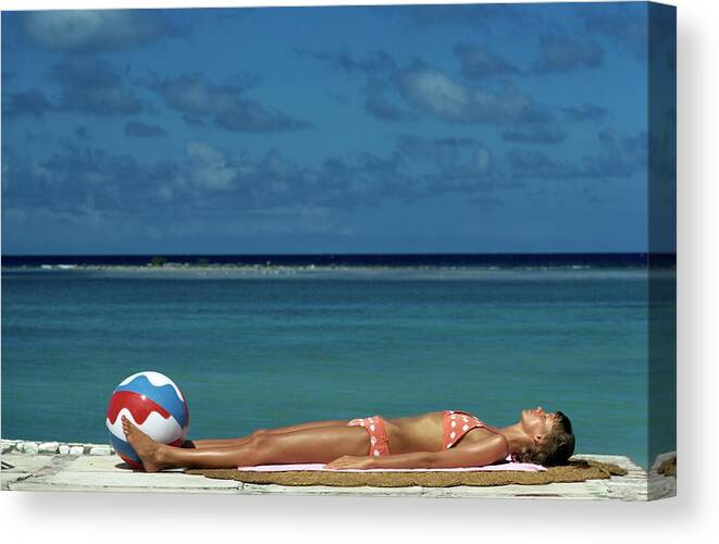 Fashion Canvas Print featuring the photograph Model Lying on the Beach in a Polka Dot Bikini by Mike Reinhardt