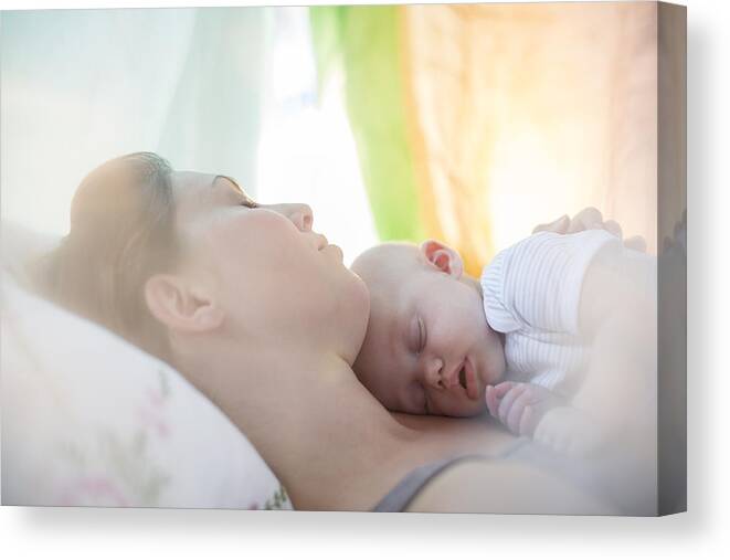 Tranquility Canvas Print featuring the photograph Mother and baby girl sleeping on bed by Tom Merton