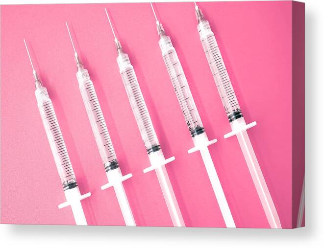 Medical Injection Canvas Print featuring the photograph Multiple Syringes With Needles on Pink Background by Grace Cary
