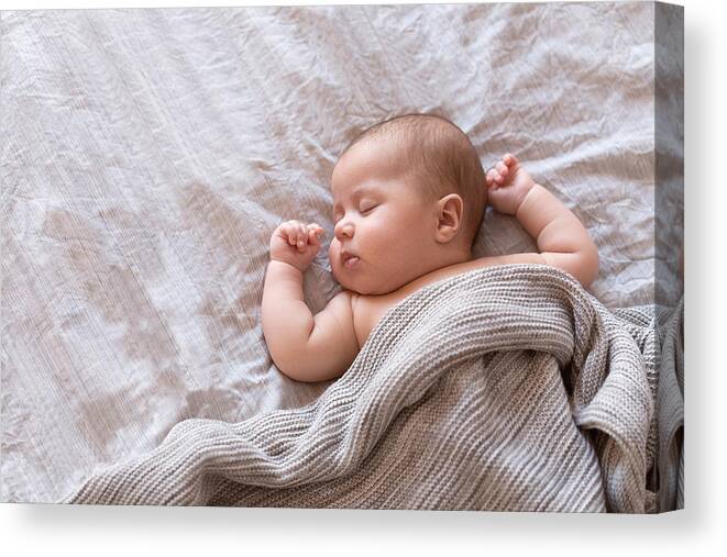 Toddler Canvas Print featuring the photograph Peaceful baby lying on a bed and sleeping at home by Amax Photo