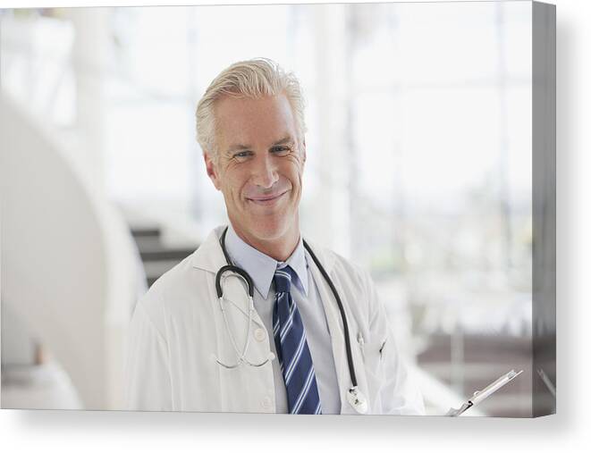 Expertise Canvas Print featuring the photograph Portrait of smiling doctor in hospital by Sam Edwards